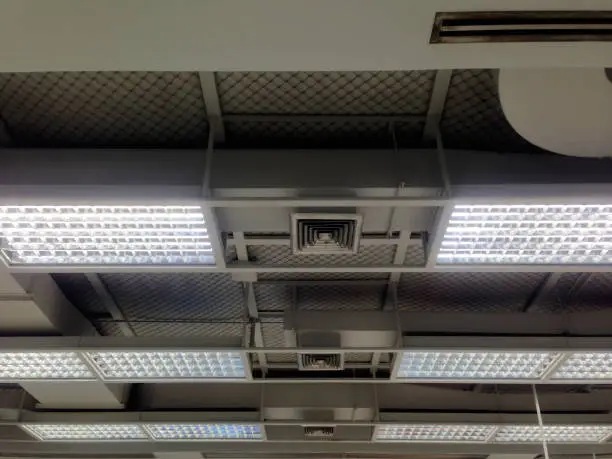Photo of Air grille and lighting system. Ducting for air conditioner. System work on the floor.