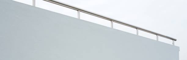istock White painted concrete wall chrome handrail with copy space 1163189680