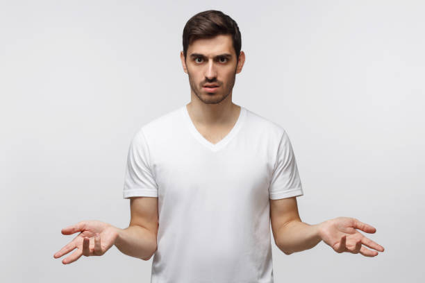 istock Young man spreading hands not knowing what to do, isolated on gray background 1163192212