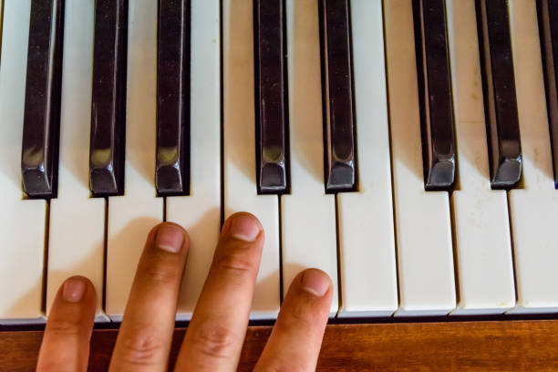 istock Child hand on the shiny piano keys. Top view 1163192323