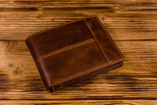 istock Closed brown leather wallet on wooden table 1163192335
