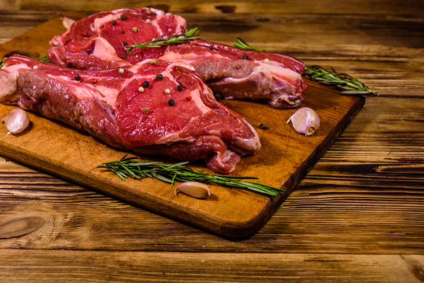 istock Raw ribeye steak, spices, rosemary and garlic on cutting board 1163192586