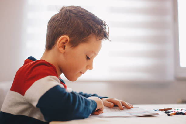 menino que faz seu trabalho ou trabalhos de casa da escola - homework pencil people indoors - fotografias e filmes do acervo