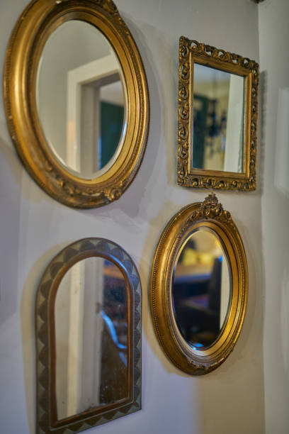 istock Assorted gilt framed mirrors hanging on a wall for decoration 1163195509