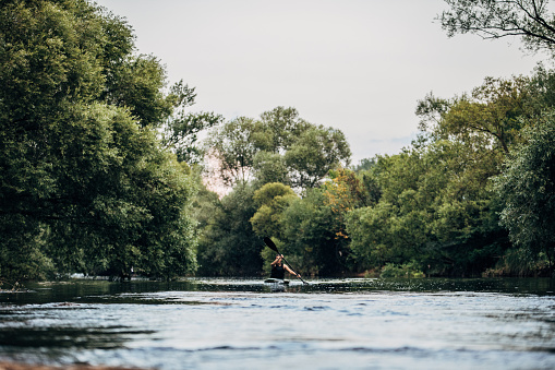 Whitewater kayaking, extreme kayaking. Woman in a kayak sails on a mountain river
