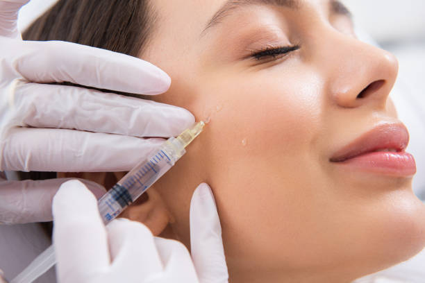 istock Smiling lady on procedure of cheek bone in salon 1163196963