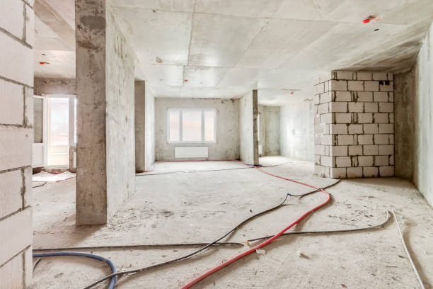 Construction site of residential apartment building interior in progress with windows and white brick wall stock photo
