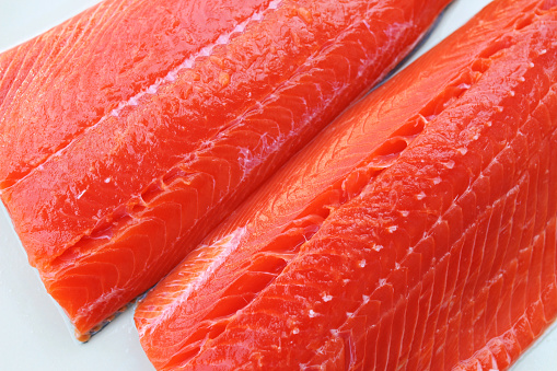 Wild-caught sockeye salmon fillets on a white background. Raw salmon fillets ready for cooking