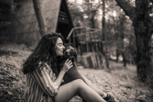 Young woman playing with dog in nature