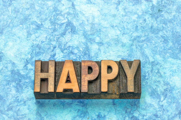 happy word in vintage letterpress wood type against blue bark paper