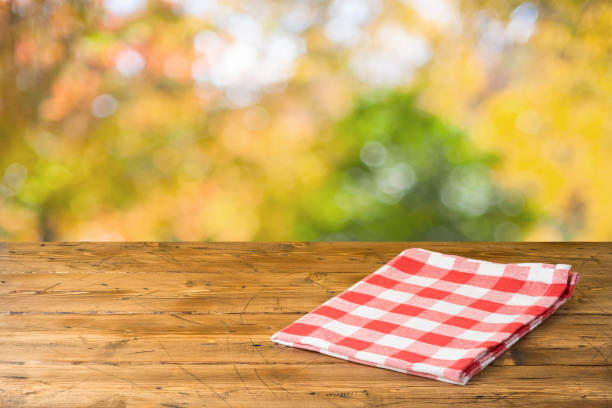 istock Empty wooden table with tablecloth over autumn nature park background 1163201119