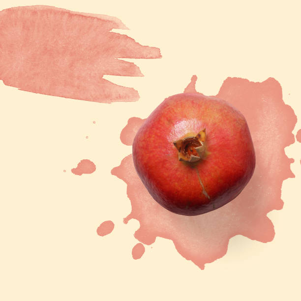 Red pomegranate on the pastel background with red watercolor stock photo