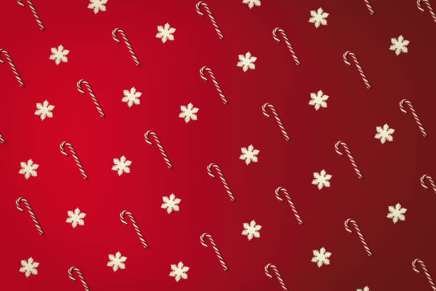 Christmas cane and snowflakes pattern top view on the red holiday background stock photo