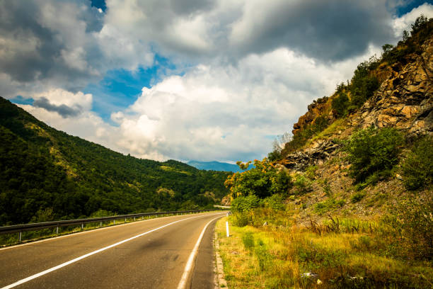 istock Road through mountain and forest, cloudy day 1163209522