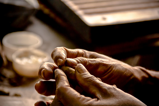 Cuban artisan folding the tip of a cigar.