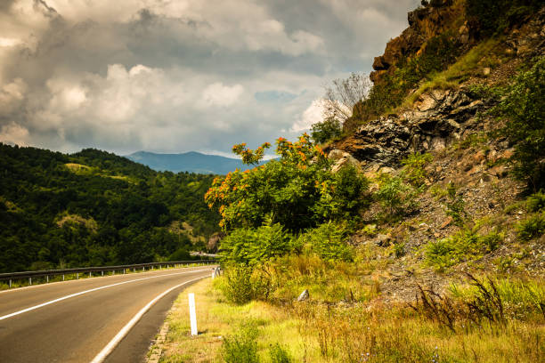 istock Road through mountain and forest, cloudy day 1163209631