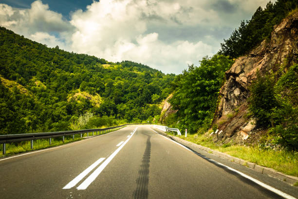 istock Road through mountain and forest, cloudy day 1163209654
