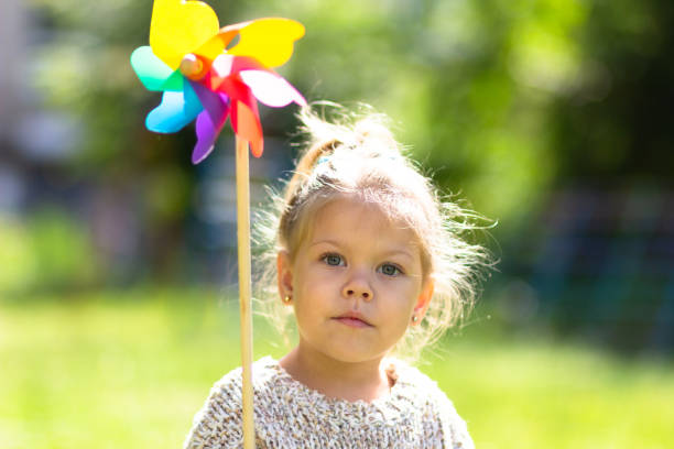 istock Child with Pinwheel in the summer park looking at camera 1163210950