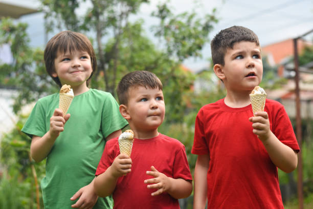istock Three happy little boy eating ice cream 1163211118