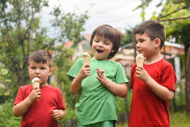 istock Three happy little boy eating ice cream 1163211265