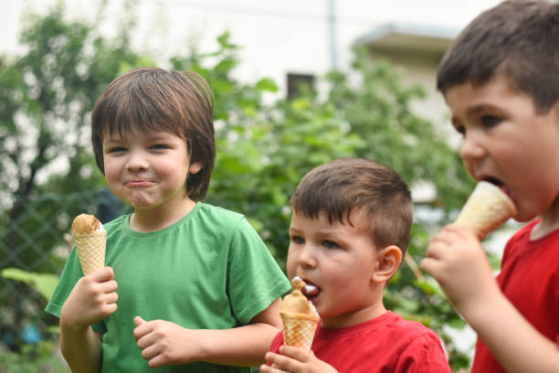 istock Three happy little boy eating ice cream 1163211433