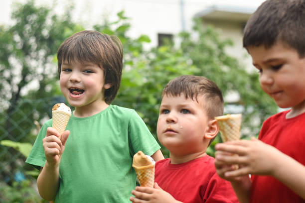 istock Three happy little boy eating ice cream 1163211980
