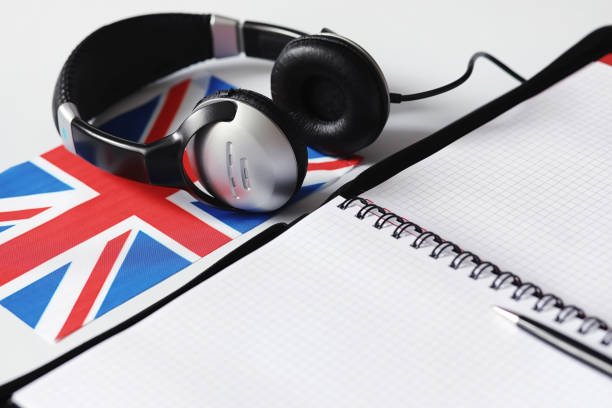 istock Learning foreign languages. Notepad for entries and a flag. Language courses, audio audition 1163212294
