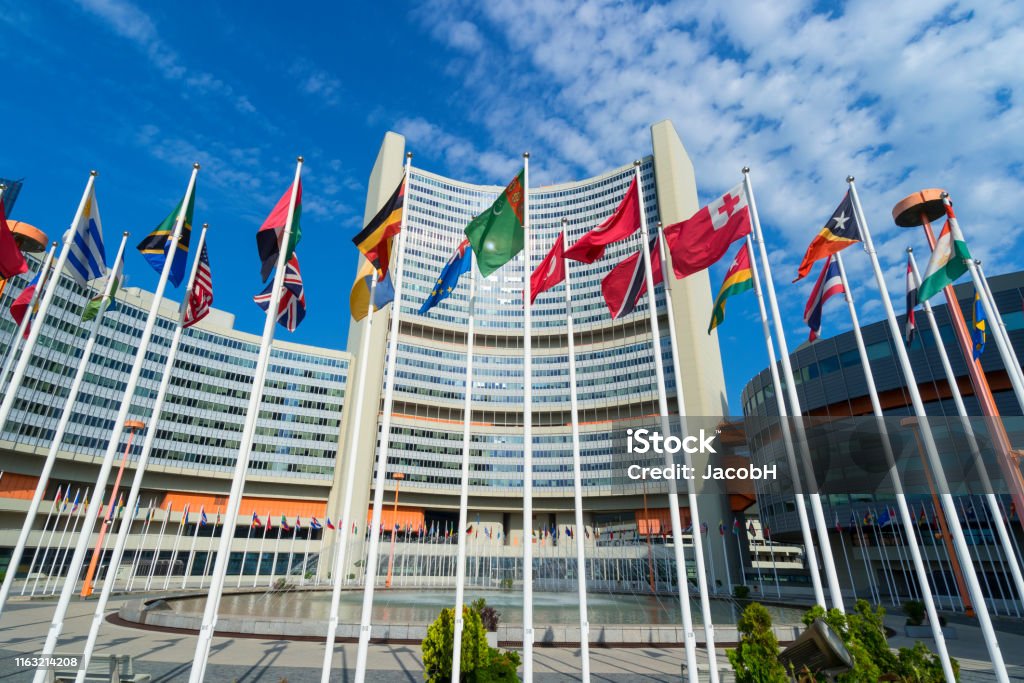 Vienna International Centre Vienna International Centre with waving flags in the foreground United Nations Stock Photo
