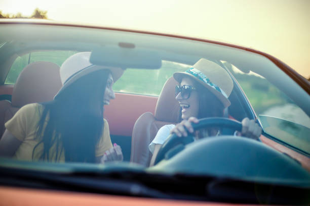 istock Girlfriends having fun on a road trip with cabriolet 1163214263