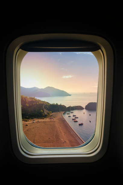 istock Airplane window with paradise beach and sea. 1163214331