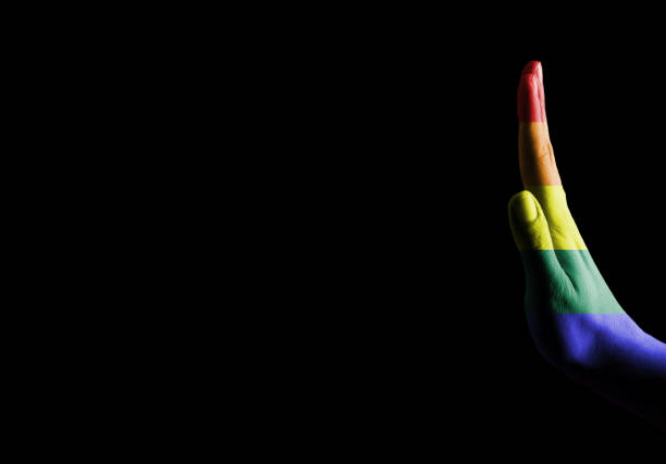 Female hand with PRIDE flag showing stop gesture / Flag concept