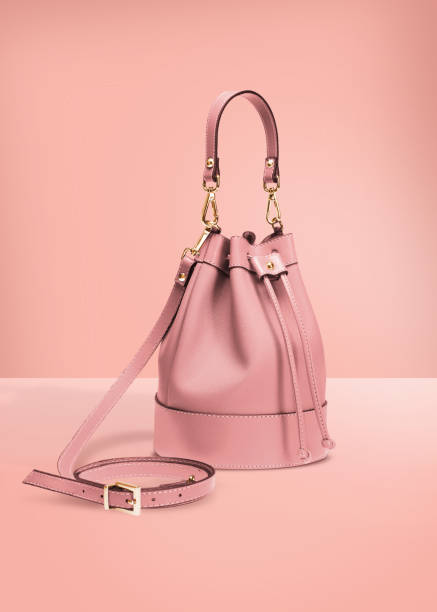 Handbag with clipping path on a pastel background Fashion photography, pink color designer bucket bag on a pastel pink background with clipping path designer clothing photos stock pictures, royalty-free photos & images