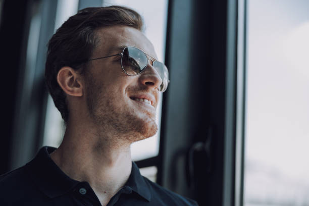 istock Unshaved young man in sunglasses smiling happily 1163217386