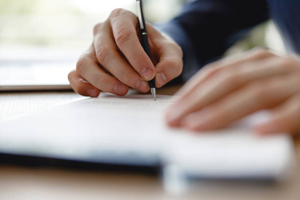 istock Black pen in the hand of man signing documents 1163217396