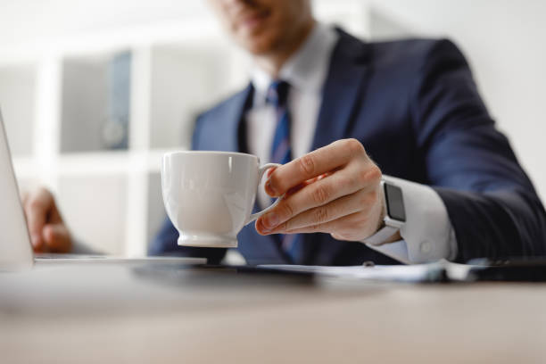 istock Selective focus of white coffee cup and hand holding it 1163217404