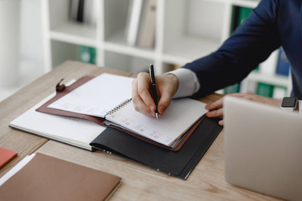 istock Close up of man making notes in his day planner 1163217411