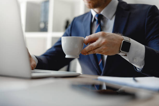 istock Hand holding cup of coffee above the table 1163217505