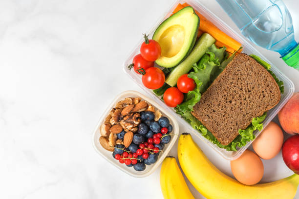 istock Lunch boxes with food ready to go for work or school. sandwich, vegetables, avocado, nuts, berries, eggs and water 1163218167