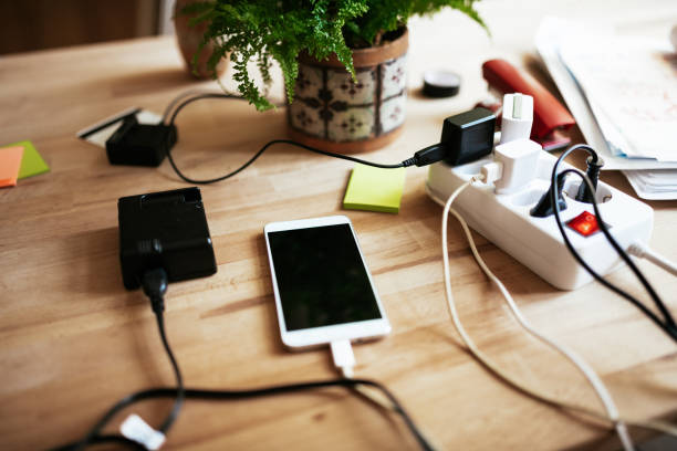 istock Mobile phone and batteries on charger 1163218673