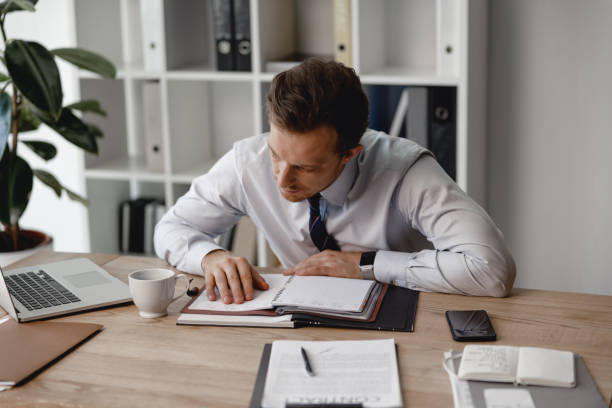 istock Attentive businessman leaning tot eh table and looking at plans 1163222211