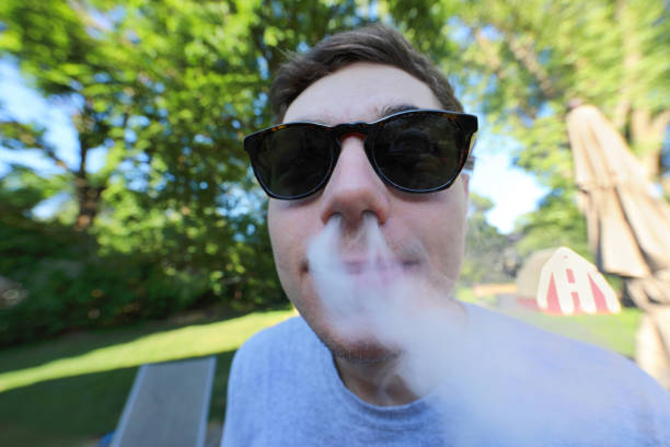 istock Wide angle view of a nerd man blowing smoke out his nose 1163230678