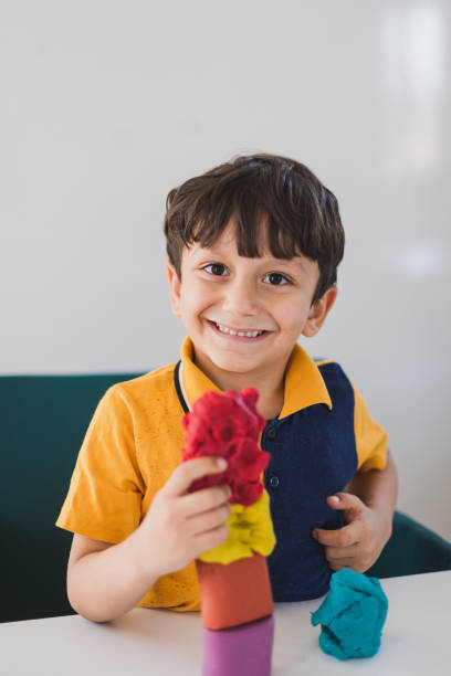 istock Creative boy playing with colorful modeling clay at nursery 1163232960