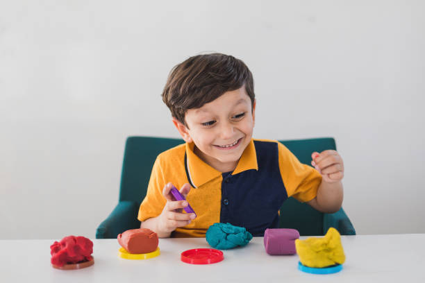 istock Creative boy playing with colorful modeling clay at nursery 1163233101