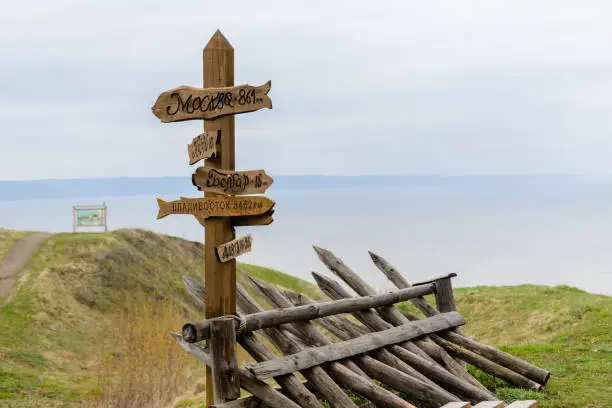 Photo of Direction arrows to the different popular towns with the distance to each city given in kilometers. Wooden signpost to Moscow, Kazan, Vladivostok, Bolgar, Alatyr. Tetyushi, Russia.