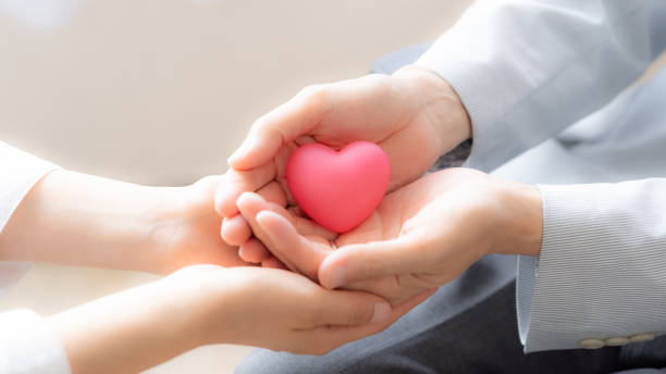 istock people holding heart symbol 1163241957