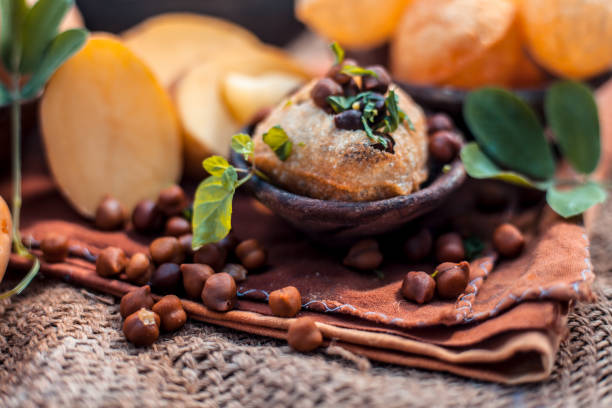 Famous Indian & Asian street food dish i.e. Panipuri snack in a clay bowl along with its flavored spicy water in another clay vessel. Entire consisting raw ingredients present on the surface. Famous Indian & Asian street food dish i.e. Panipuri snack in a clay bowl along with its flavored spicy water in another clay vessel. Entire consisting raw ingredients present on the surface. panipuri stock pictures, royalty-free photos & images