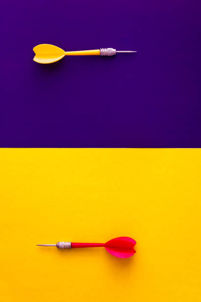 istock Multicolored red yellow green darts arrows on yellow violet blue background. Flat lay. View from above. Copy space. The concept of hitting the target, dedication 1163243029