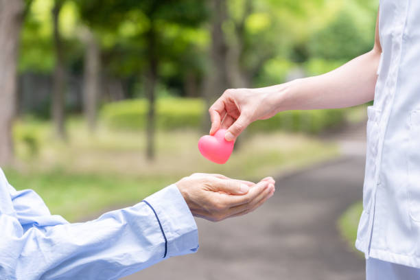 istock people holding heart symbol in park 1163244196