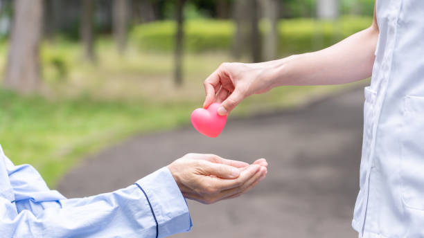 istock people holding heart symbol in park 1163244202