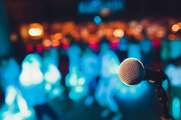 microphone on a stand up comedy stage with colorful bokeh, high contrast image. stock photo